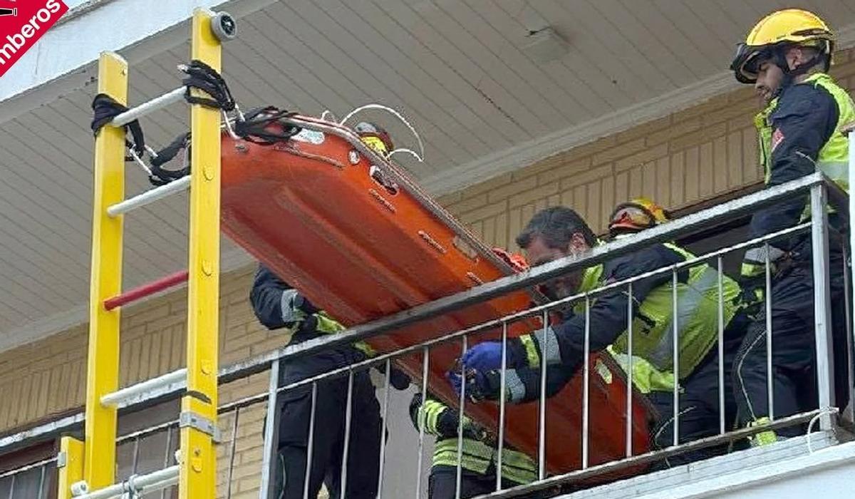 Momento en el que los bomberos bajan a la mujer, a la que inmovilizaron en la camilla de rescate