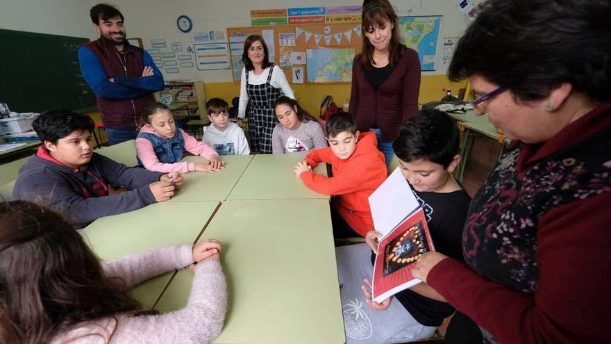 Mohamed Douahi muestra, con Encarna González, su libro a sus compañeros en presencia de Juan Miguel Molinero.