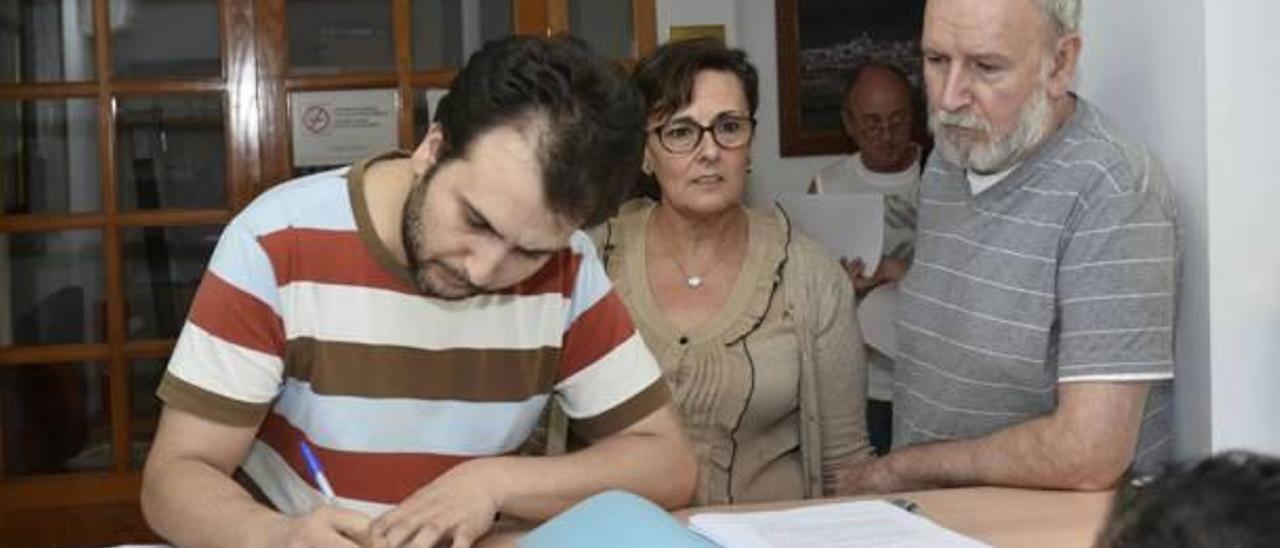 Dos miembros de la plataforma flanquean a la portavoz socialista de Vallada en la presentación de las firmas.