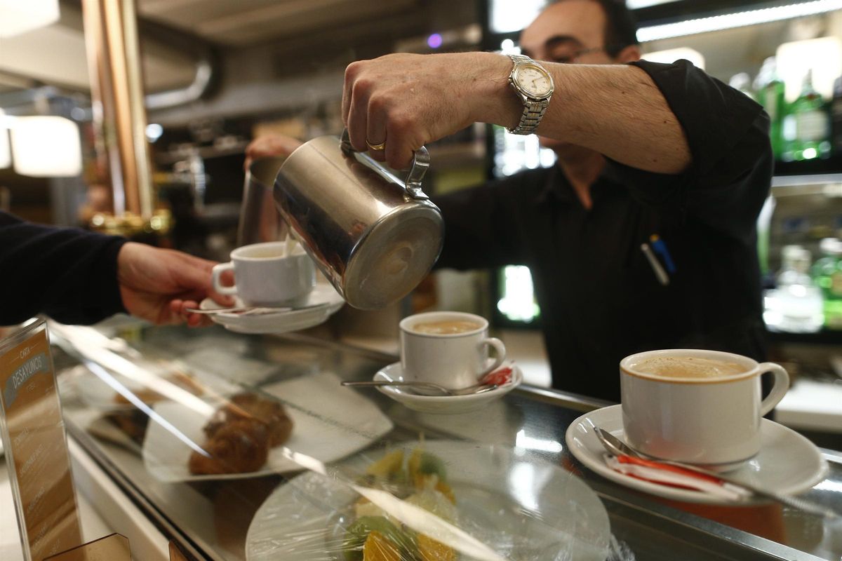 Un camarero sirve un café.