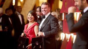 Martha Ruiz y Brian Cullinan, representantes de PreicewaterhouseCoopers, sostienen los maletines con los sobres ganadores en la gala de los Oscars. 