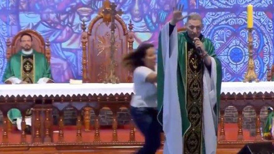 Una mujer tira al suelo a un sacerdote en plena misa