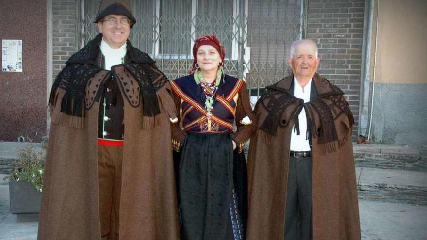 En el centro Rafaela Fernández, costurera de las capas pardas junto a dos alistanos vistiendo la prenda.