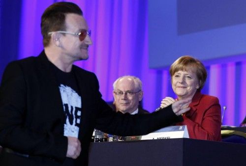 German Chancellor Merkel and European Council President Van Rompuy look on as singer Bono arrives at the European People's Party (EPP) Elections Congress in Dublin