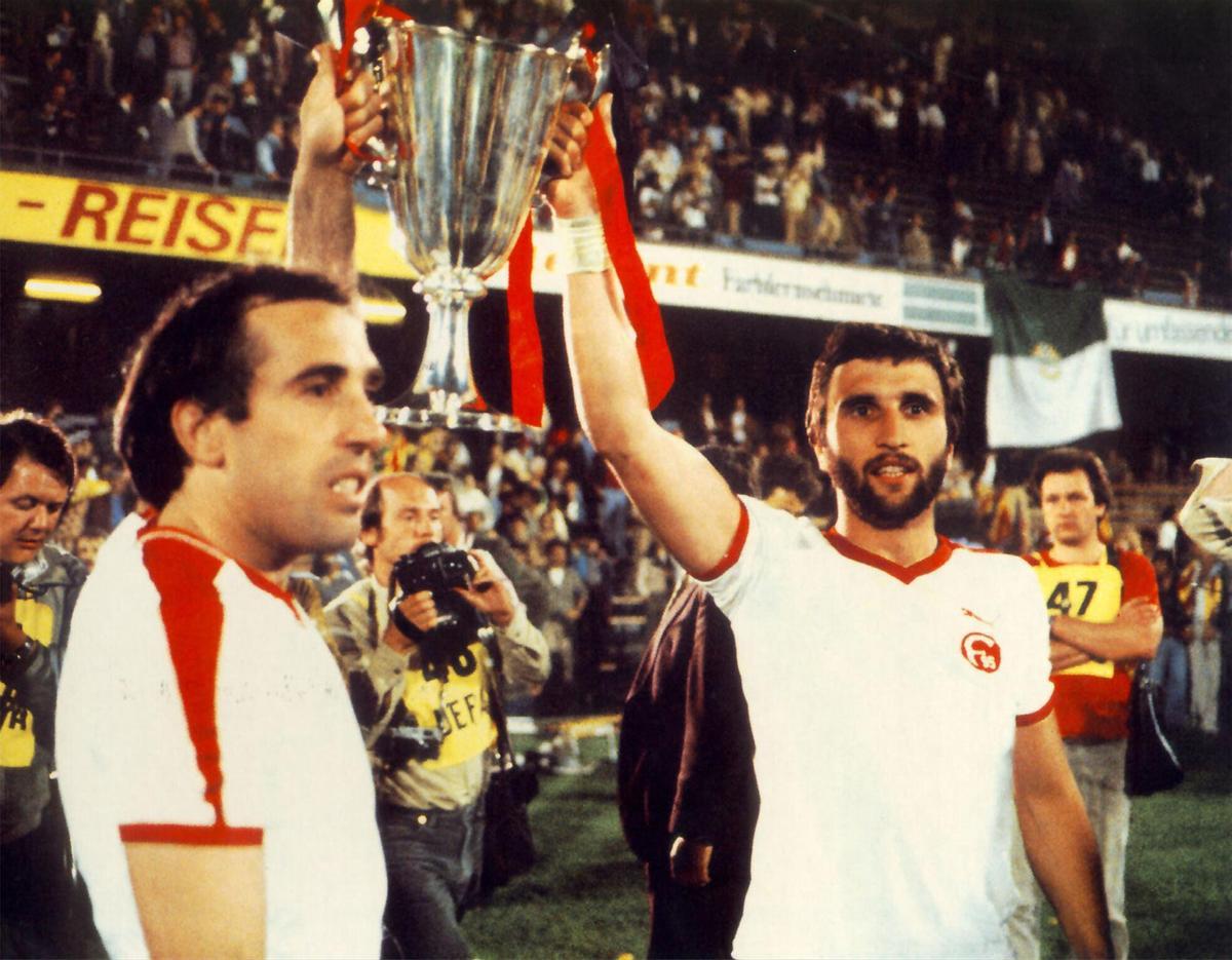 Hansi Krankl y Juan Manuel Asensi levantan la Recopa en St. Jakobs Park enfundados con la camiseta del rival, el Fortuna Dusseldorf