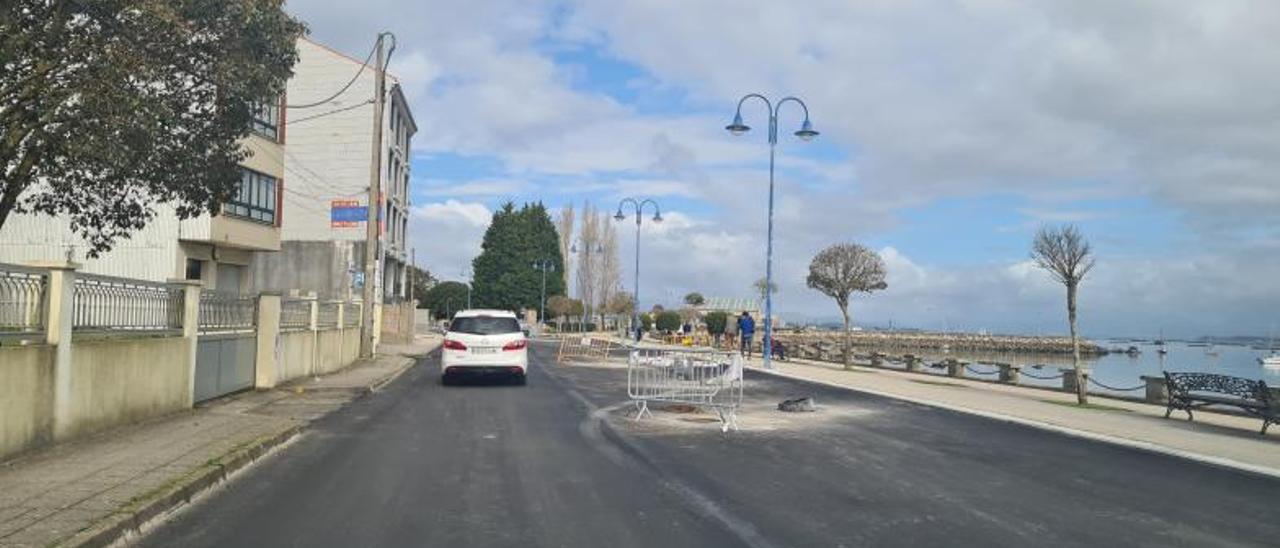 Un vehículo circula por la calle, aún en obras.