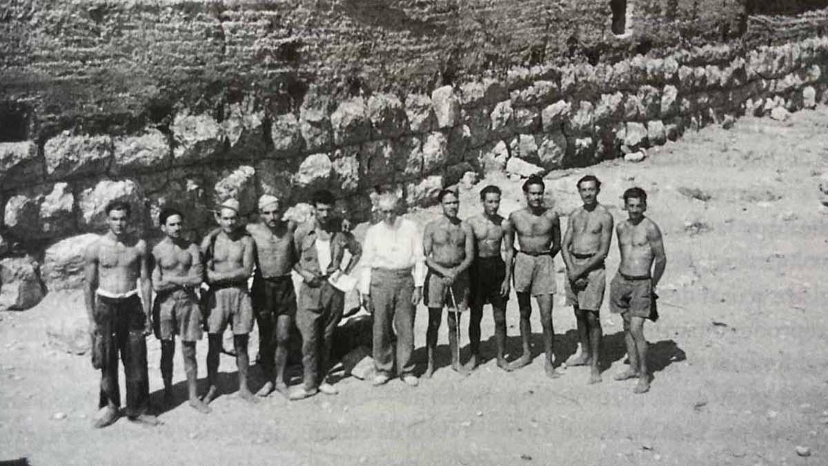 Un grupo de soldados trabajadores del batallón 46 delante de la muralla romana del yacimiento de Empúries