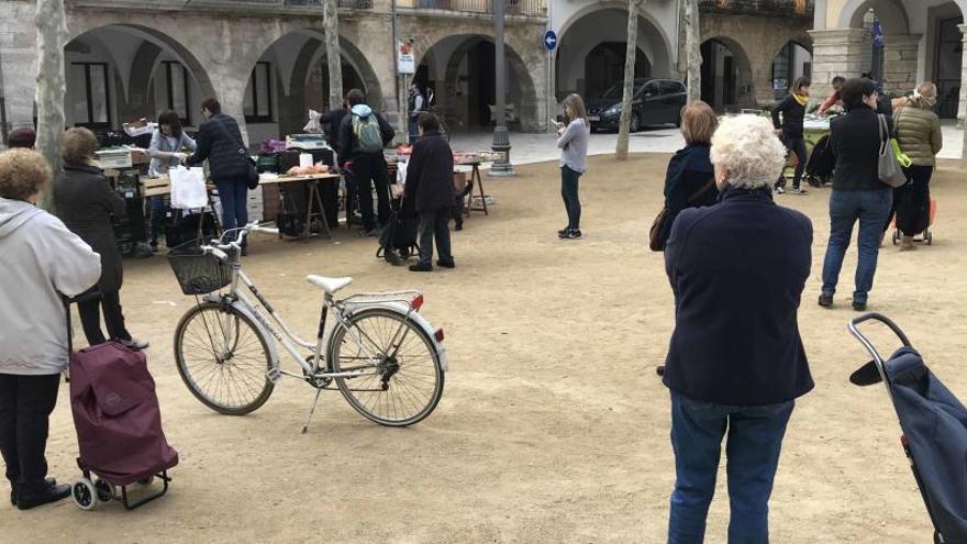 Gent fent cua mantenint la distància de seguretat a Banyoles