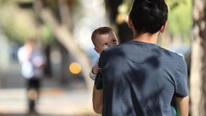 Un bebé observa a su padre mientras ambos pasean por una de las calles de la comuna de Providencia este miércoles en Santiago (Chile). 