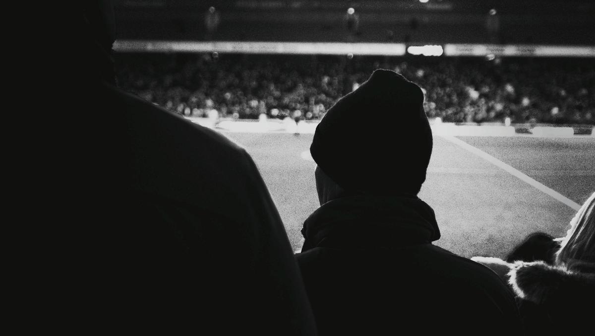 Aficionados en un campo de fútbol.