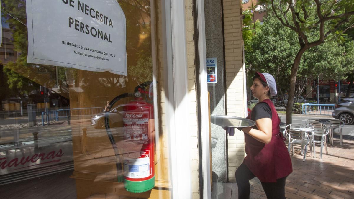 Una camarera lleva una bandeja en una heladería de Alicante.