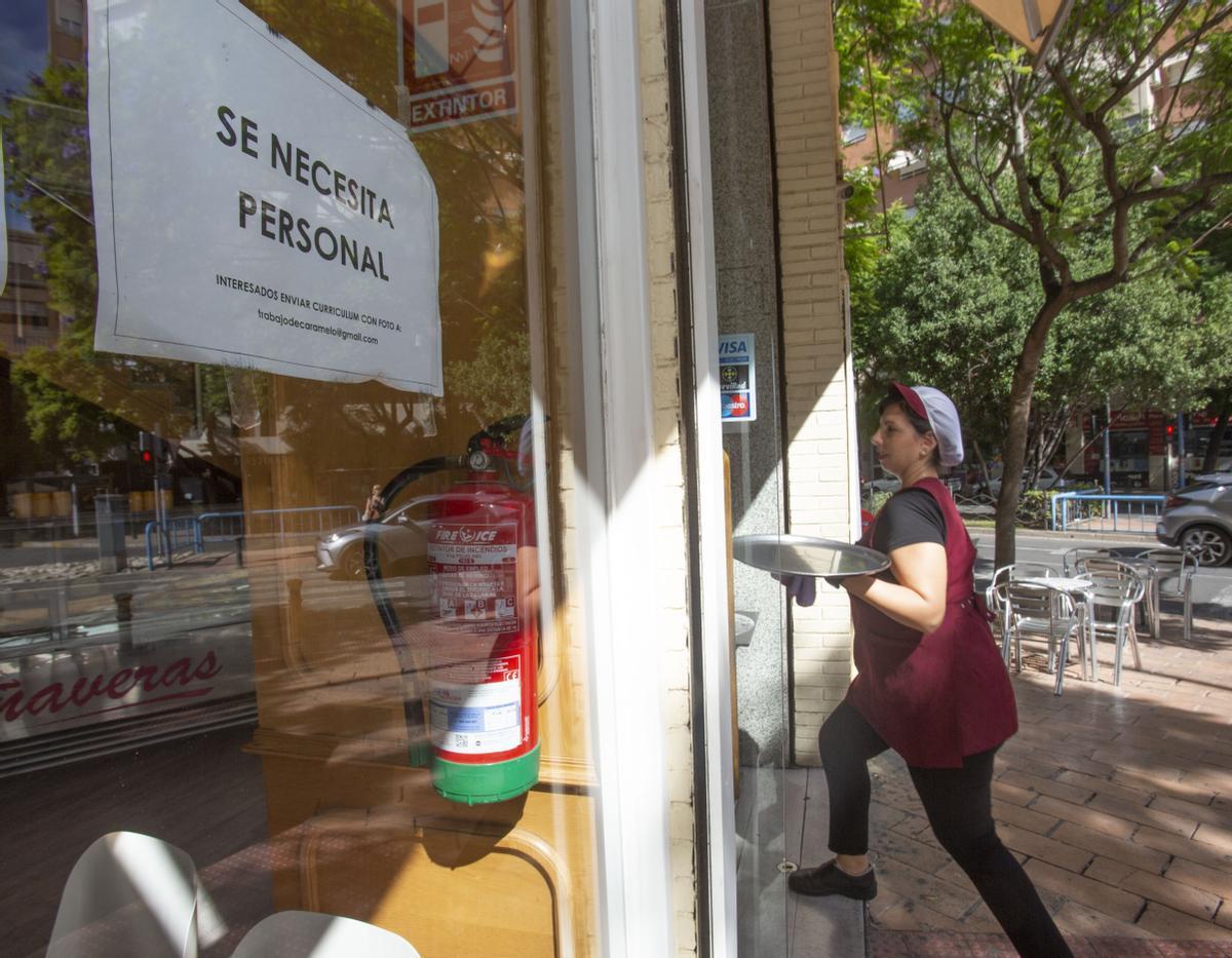 Una camarera lleva una bandeja en una heladería de Alicante.