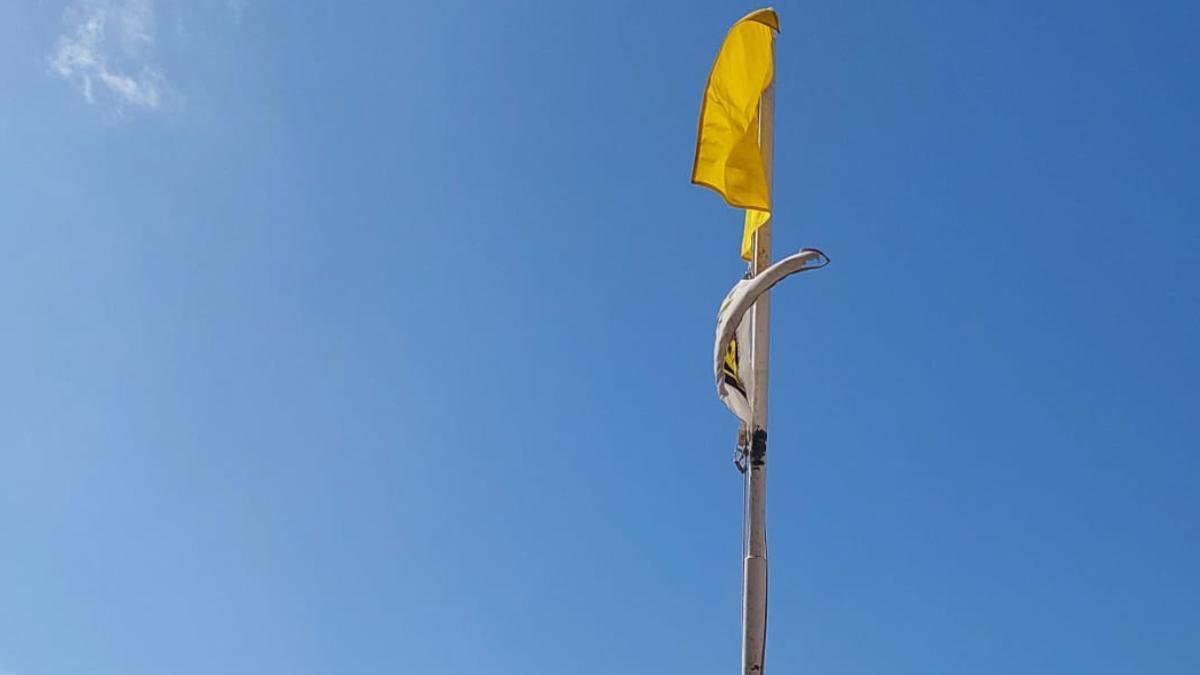 Imagen de archivo de una playa con bandera amarilla.
