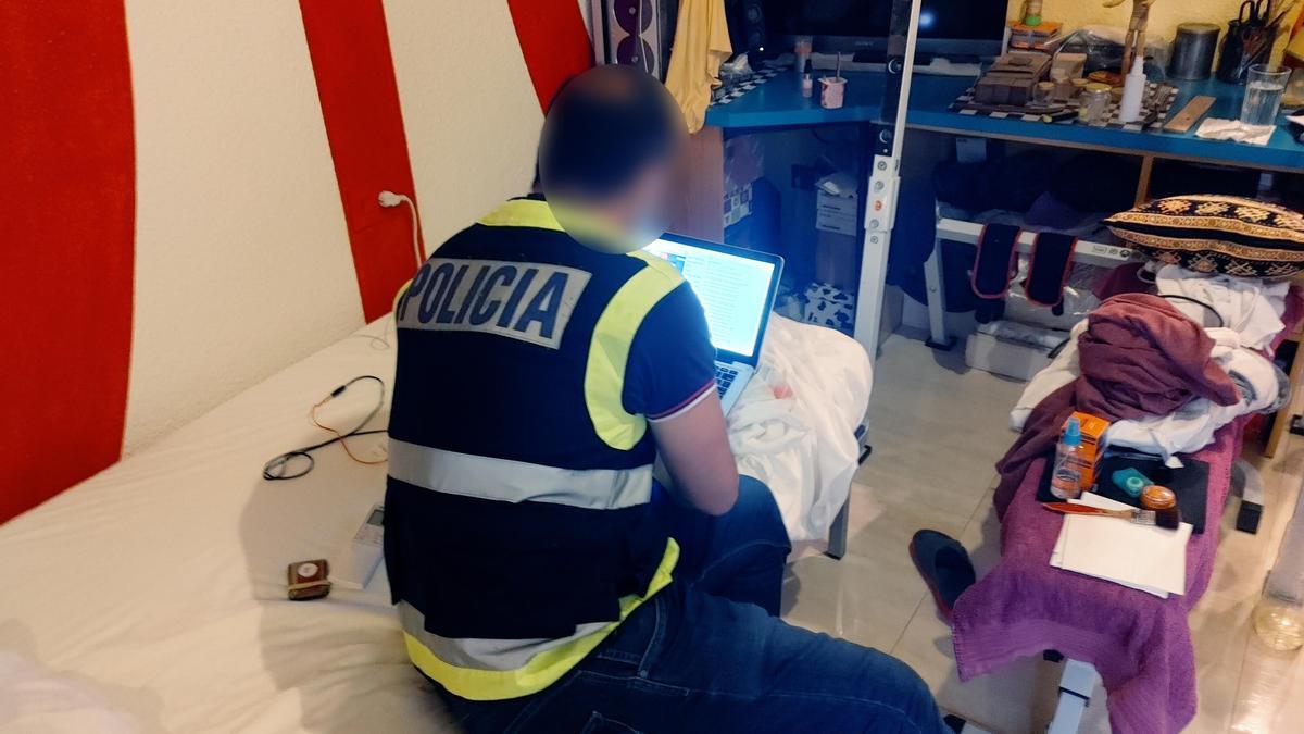 Un agente durante el registro de la vivienda del detenido.