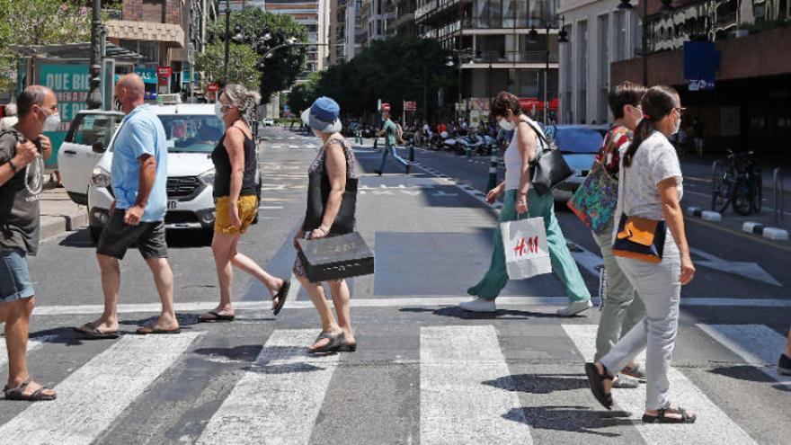 Gente paseando por la calle Colón de València con las mascarillas puestas.