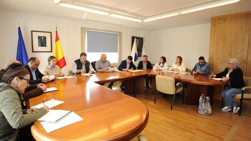 El alcalde ojea unos documentos en un pleno en presencia de Seijas y Tato.