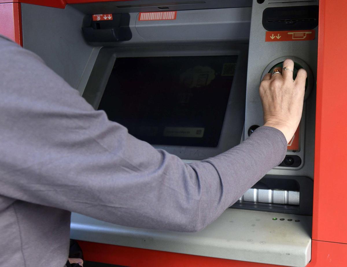 Una mujer en un cajero del centro de Murcia.
