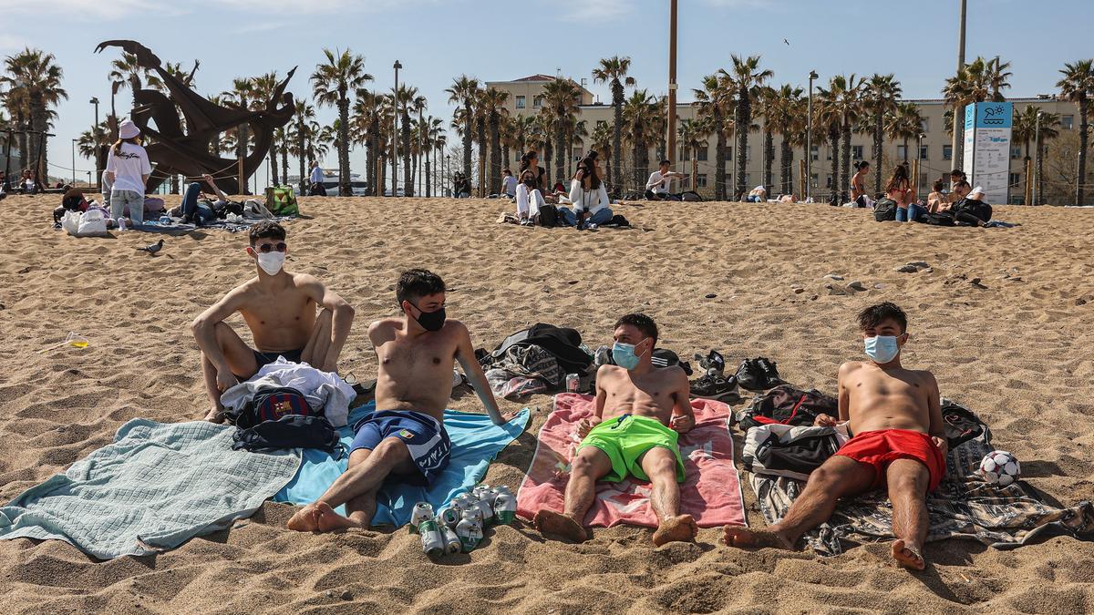 Un grupo de jóvenes con mascarilla en la playa de la Barceloneta