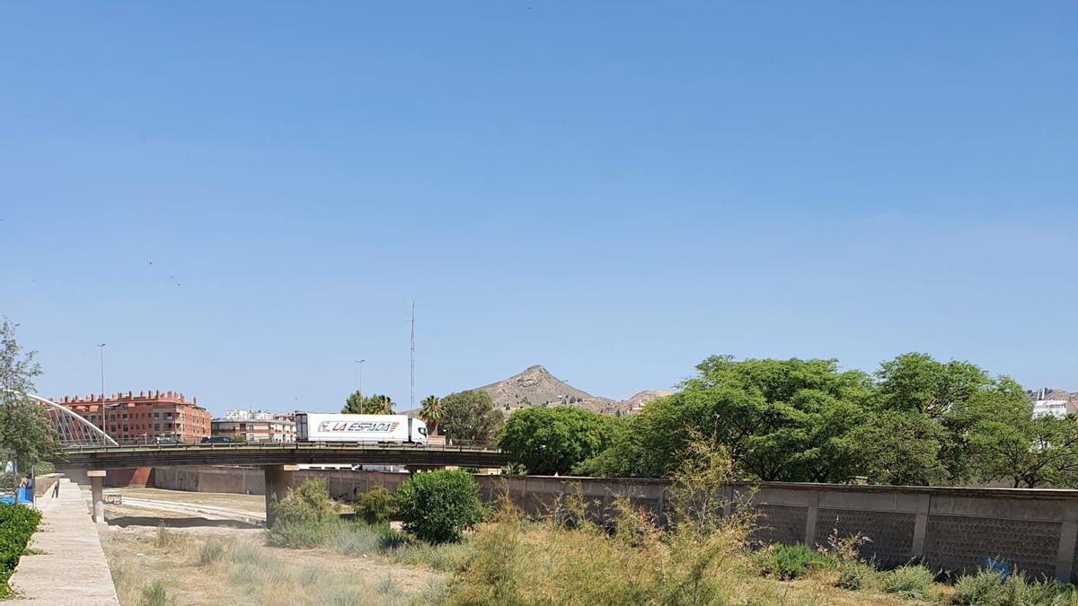 Una máquina desbrozando el cauce del río a su paso por la ciudad.