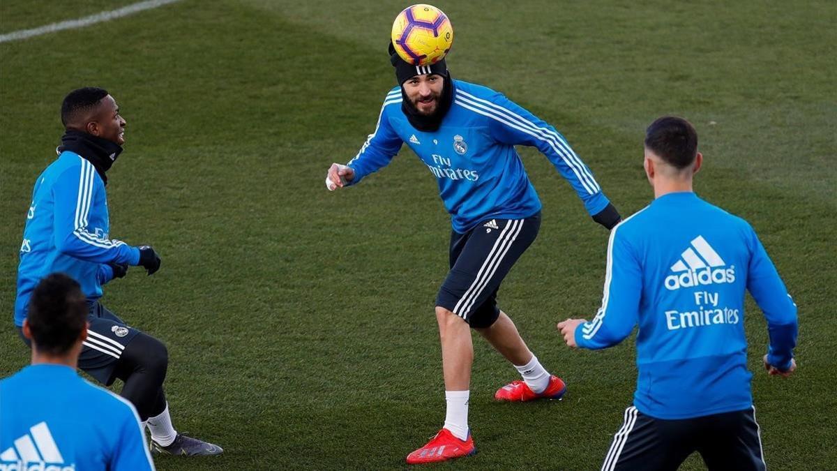 Benzema toca de cabeza ante Vinicius y Asensio en Valdebebas.