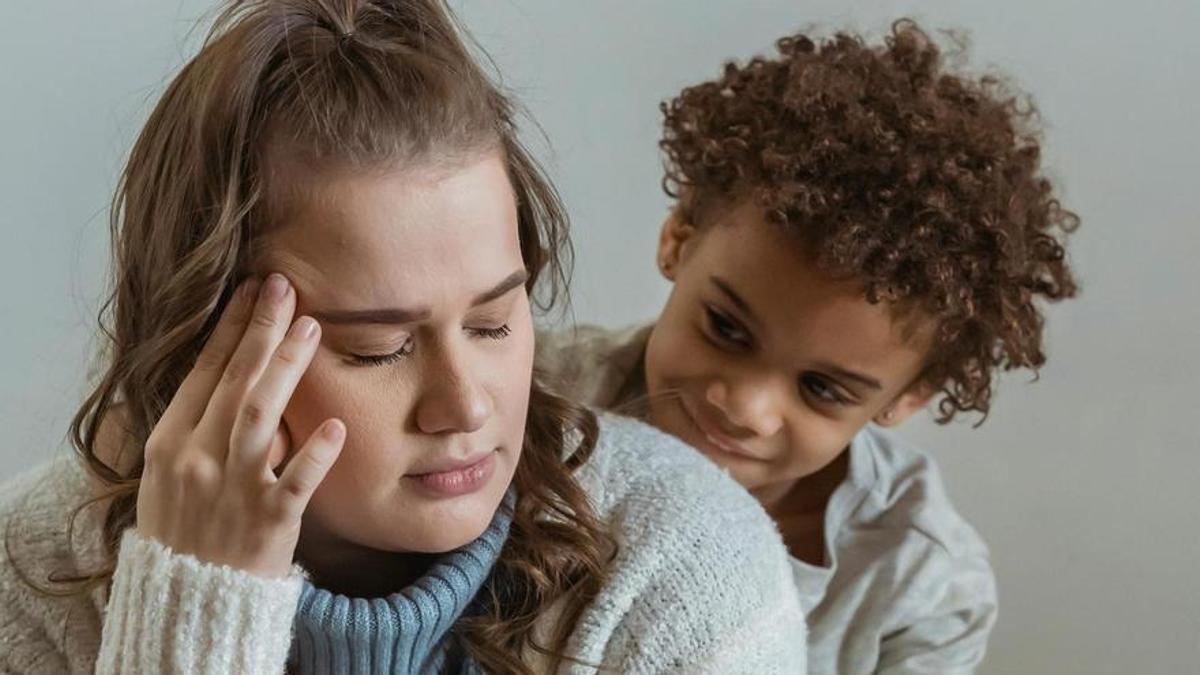 Una madre cansada mientras su hijo la mira