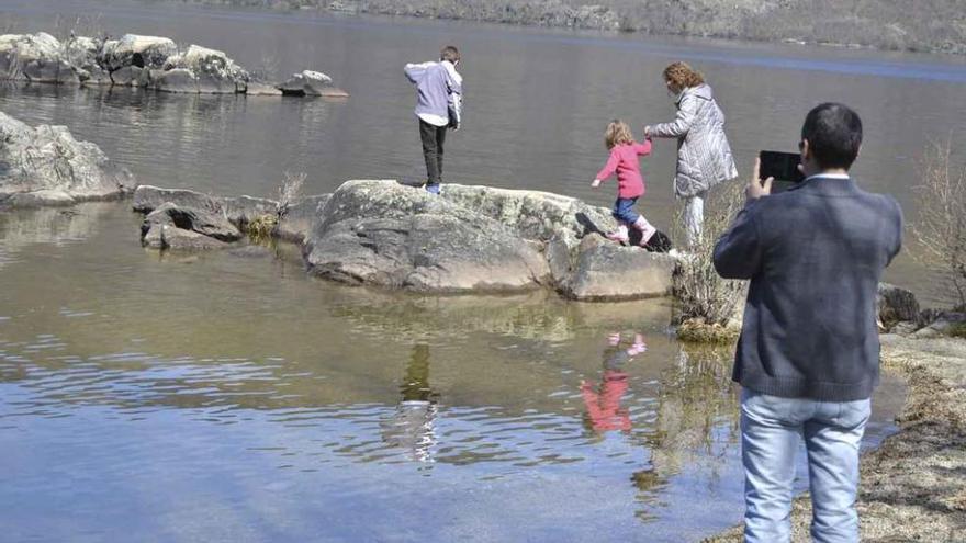 Una familia visita el Lago de Sanabria y disfruta recorriendo sus peñas.