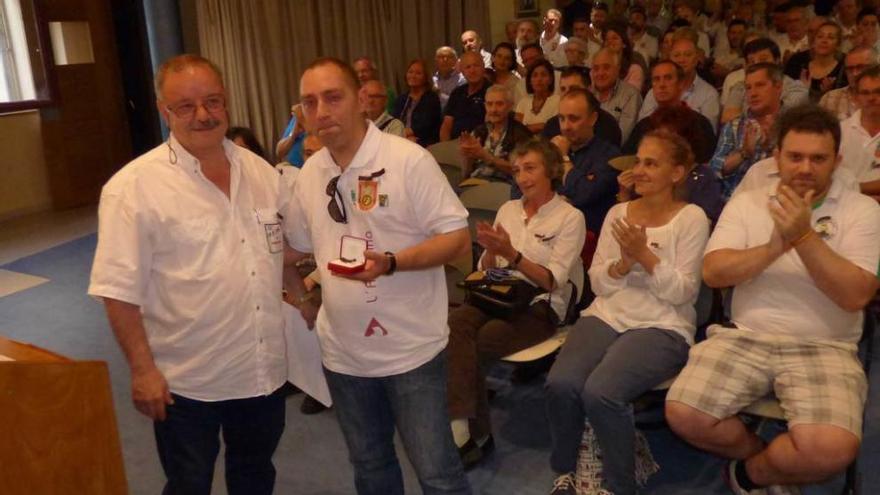 Juan Fernández entrega la medalla de oro a Tim Herrero, nieto del homenajeado Fernando Graña.