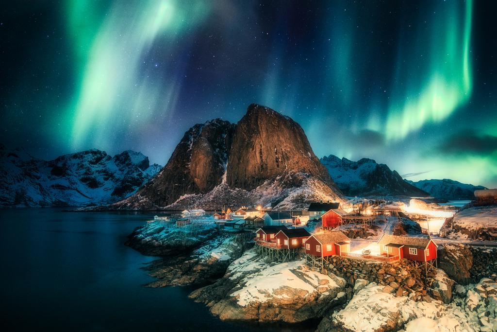 Aurora boreal sobre un pueblo de pescadores en la costa de Hamnoy