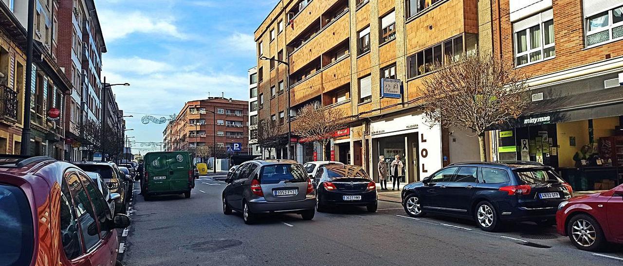 Un vehículo adelanta a otro en doble fila, con una furgoneta invadiendo el carril izquierdo, también en doble fila, ayer, en la avenida de Oviedo de El Berrón. | S. Arias