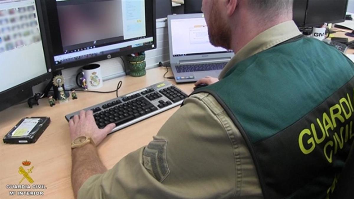 Un agente de la Guardia Civil llevando revisando parte del material incautado.