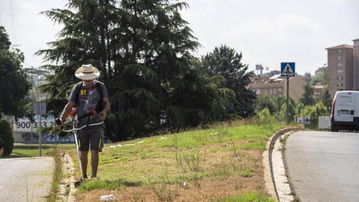 Un treballador netejant en plena canícula aquest juliol a Manresa