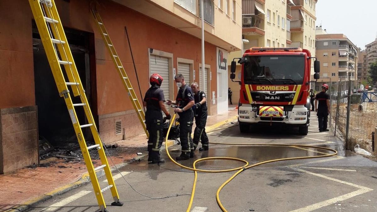 Bomberos durante las labores de extinción del incendio provocado por la explosión de un coche.