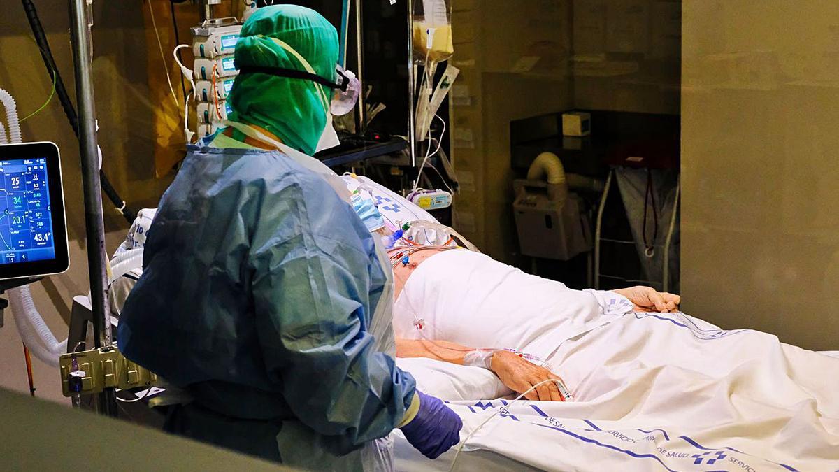 Un sanitario atiende a un paciente infectado por Covid-19 en el Hospital Negrín.