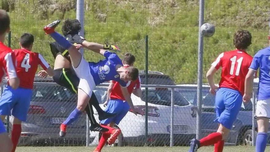 El portero internacional del Sporting Javier Izquierdo despeja un balón ante un atacante del Oviedo.