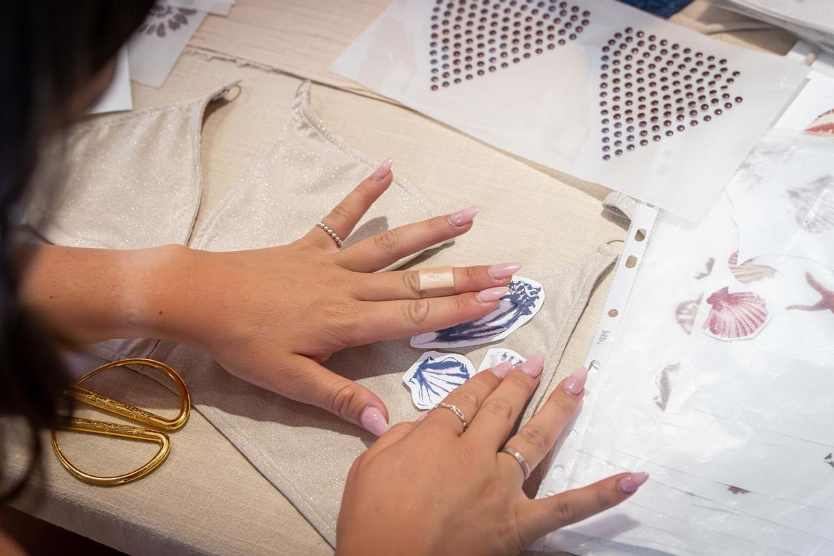 Participantes en la Bikini Lab  seleccionan y recortan estampados para customizar sus propios bikinis. La Bikini Lab son unos talleres virales en los que los asistentes pueden confeccionar su propio bikini en menos de dos horas en Camila CTG Calaf 14. Barcelona, 19 de mayo de 2026. Barcelona. AUTOR: Manu Mitru | EPC