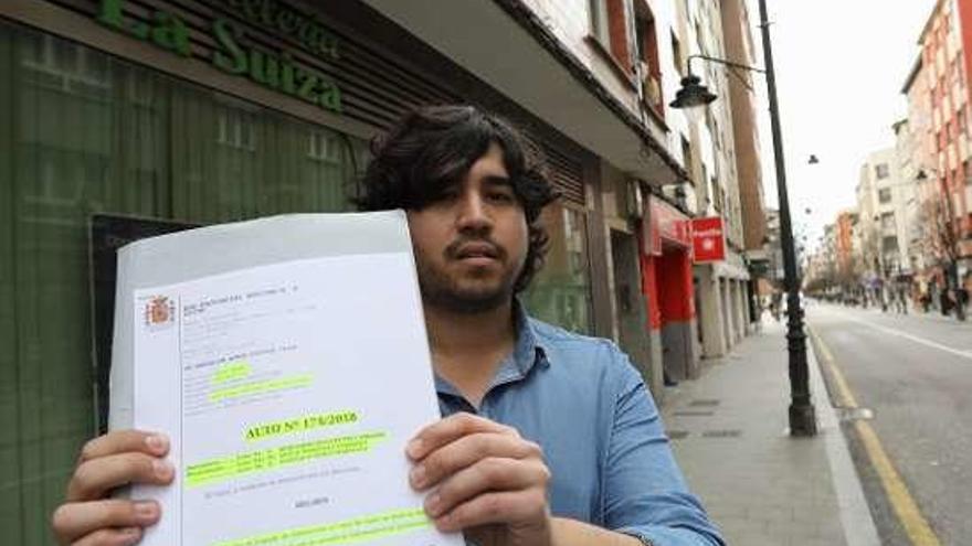 Pablo Álvarez, con el auto de la Audiencia que archivó la causa contra su padre, ante la pastelería La Suiza.