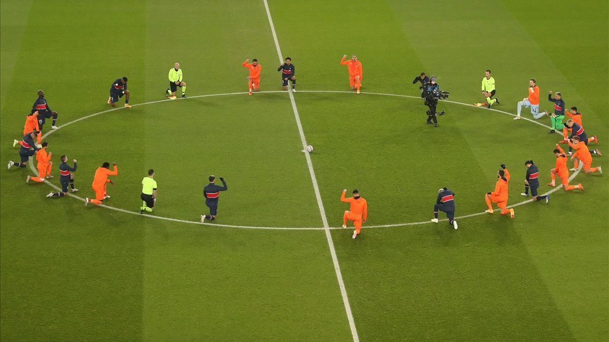 TOPSHOT - Football players and referees kneel on the pitch against racism before the UEFA Champions League group H football match between Paris Saint-Germain (PSG) and Istanbul Basaksehir FK at the Parc des Princes stadium in Paris  on December 9  2020  (Photo by XAVIER LAINE   POOL   AFP)