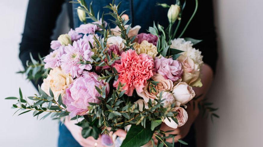 Una mujer sostiene un ramo de flores.