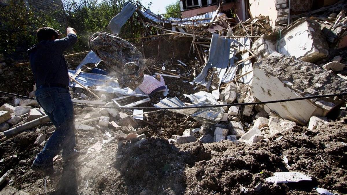 Un hombre busca enseres entre los escombros de su casa derrumbada en los bombardeos de Stepanakert.