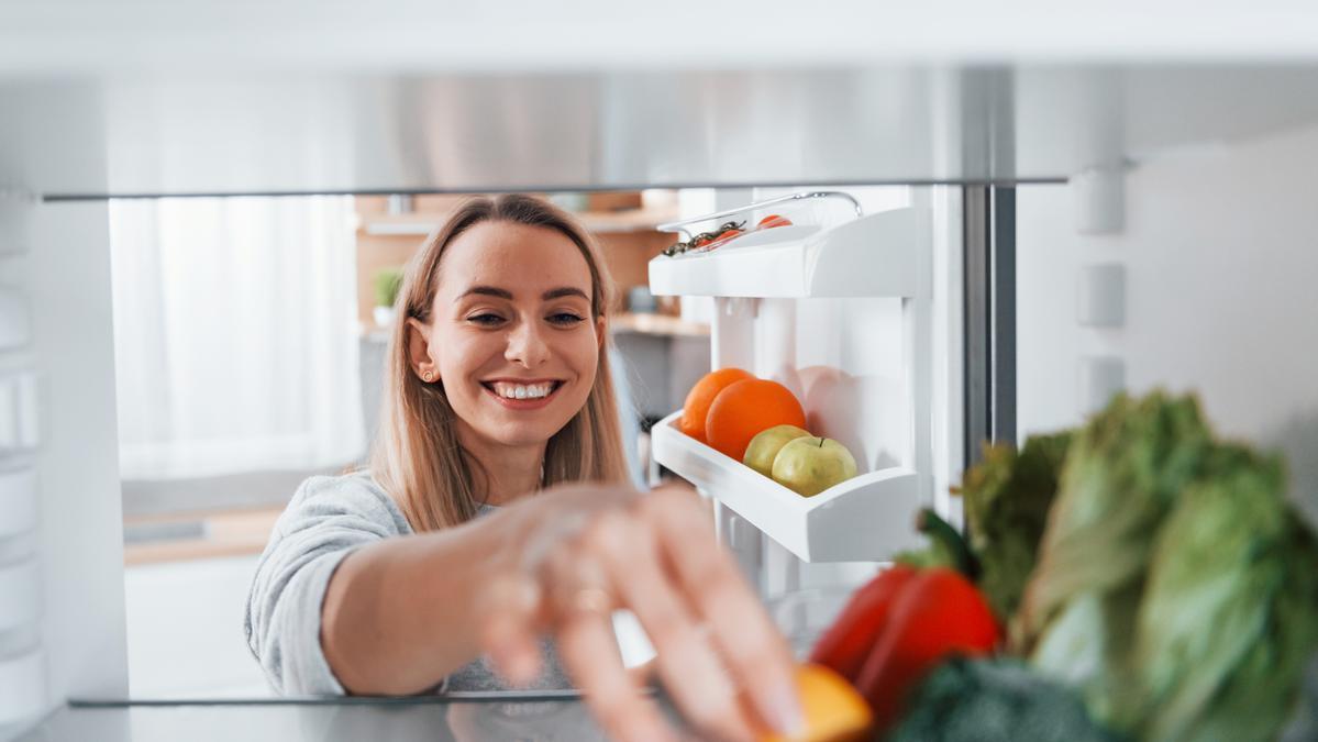 Una mujer introduce alimentos en una nevera