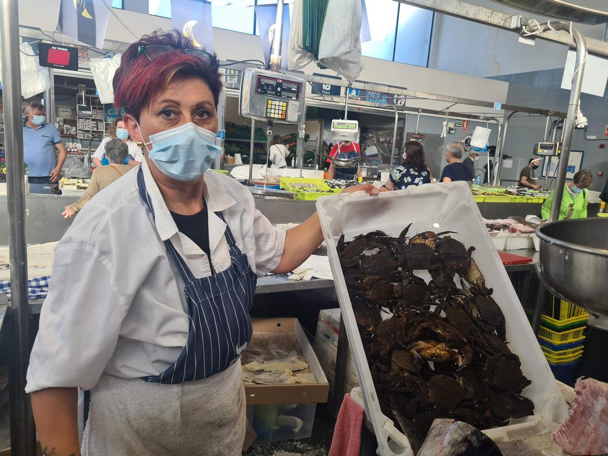 Peregrina Abad, una de las vendedoras de la plaza, mostrando una caja de nécora grande. Peregrina Abad, una de las vendedoras de la plaza, mostrando una caja de nécora grande.