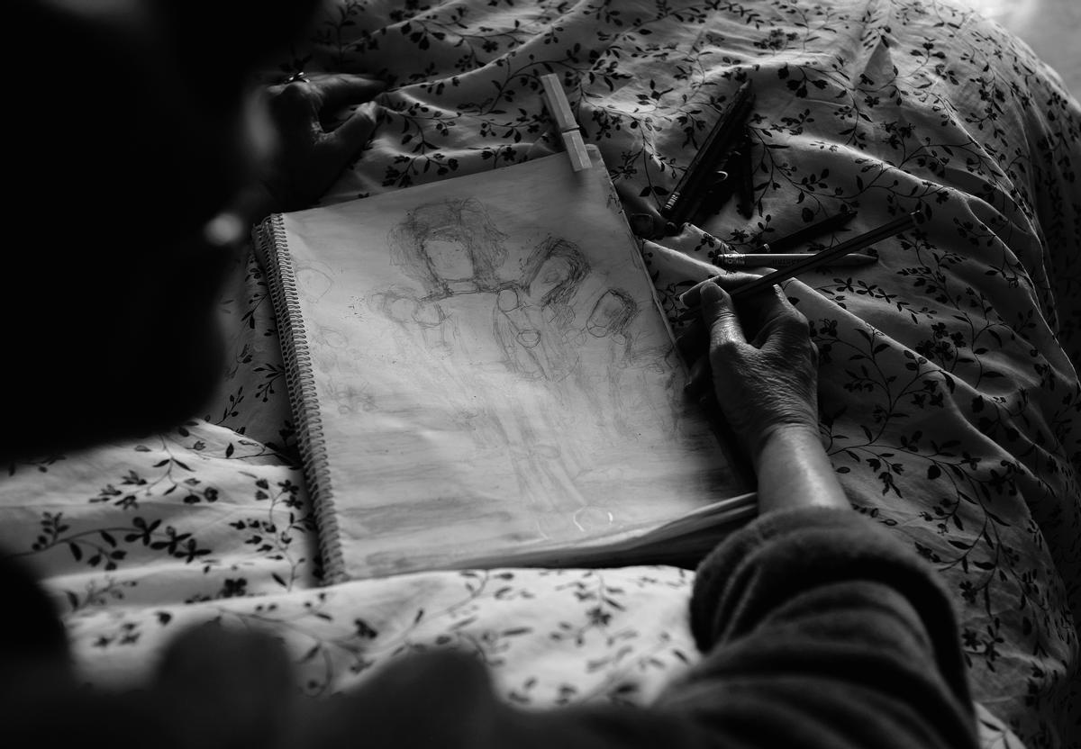 María Isabel con su cuaderno de dibujo.