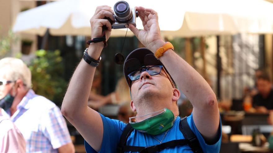 Un turista toma una fotografía en la capital malagueña.