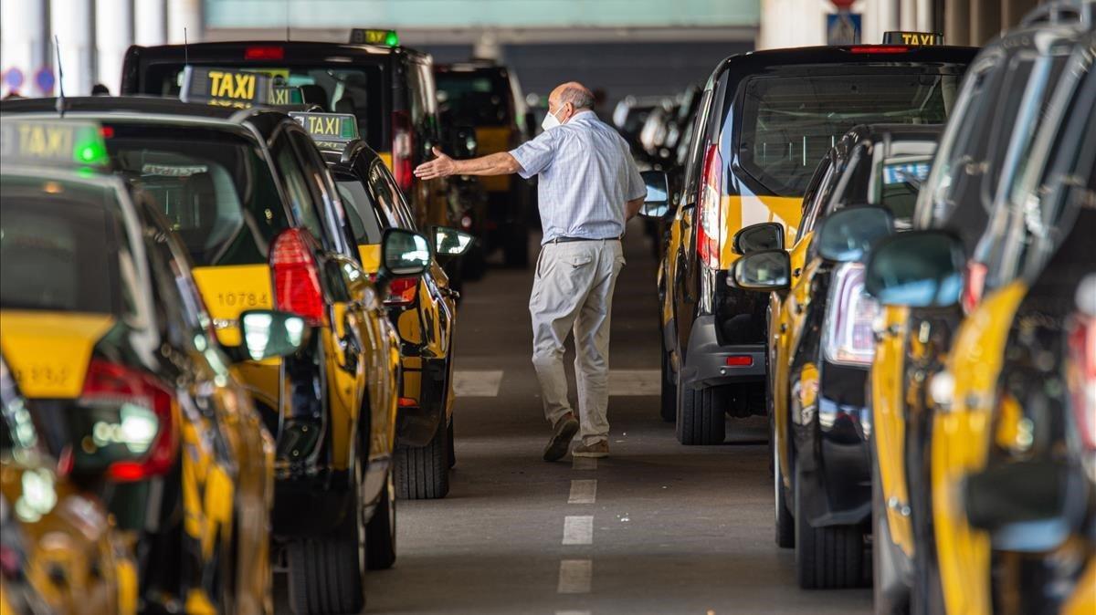 Taxistas de brazos cruzados, en la parrilla de la T1 del aeropuerto de El Prat, este sábado 