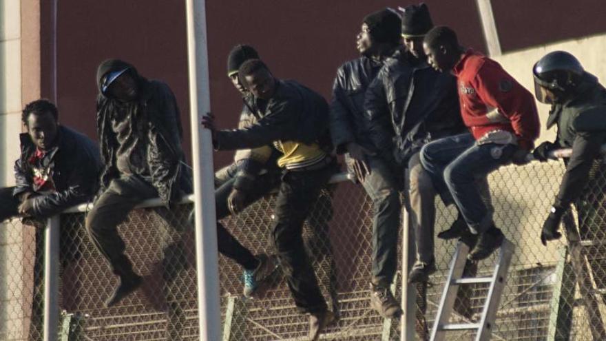 Migrantes intentando saltar la valla de Melilla.