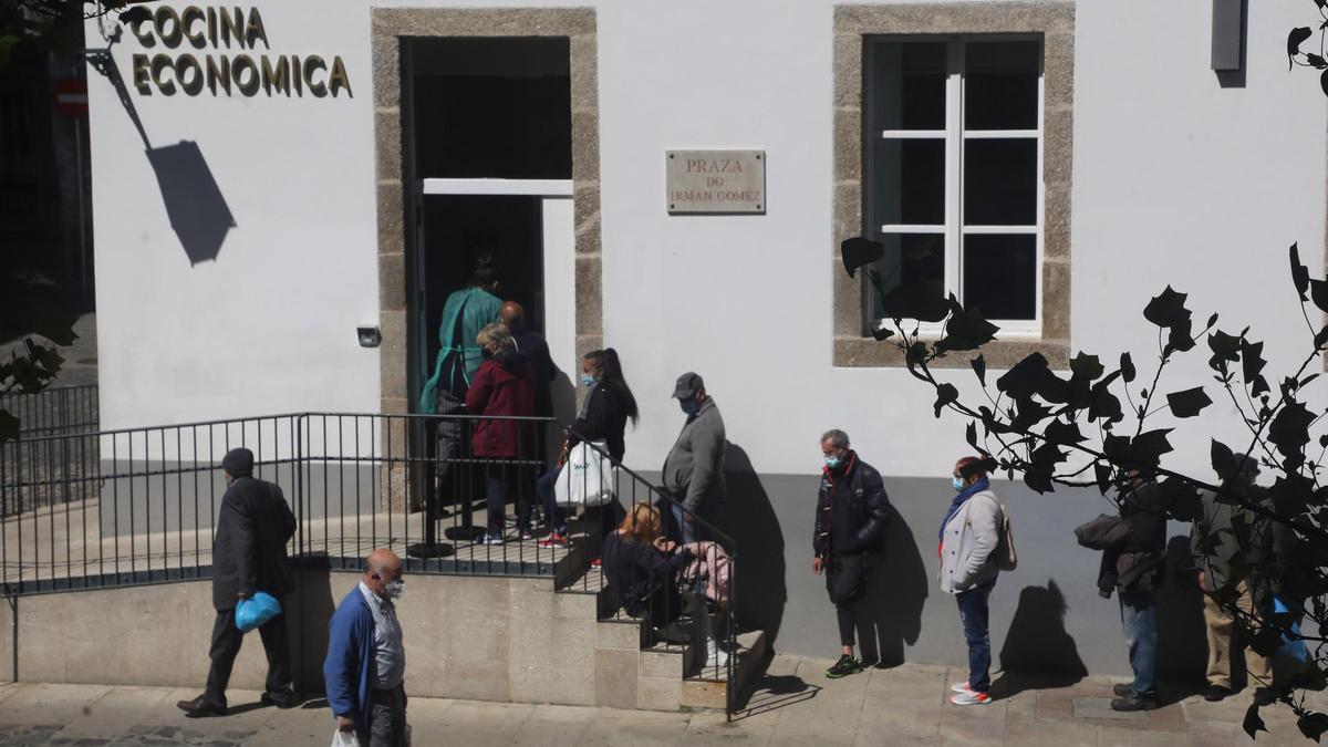 Personas esperando para entrar en una cocina económica en Santiago.