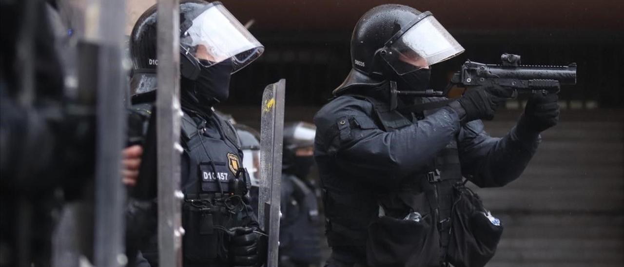 Agentes antidisturbios de los Mossos d’Esquadra en Salt, Girona, actúan ante los alborotos tras la visita del líder de Vox, Santiago Abascal.