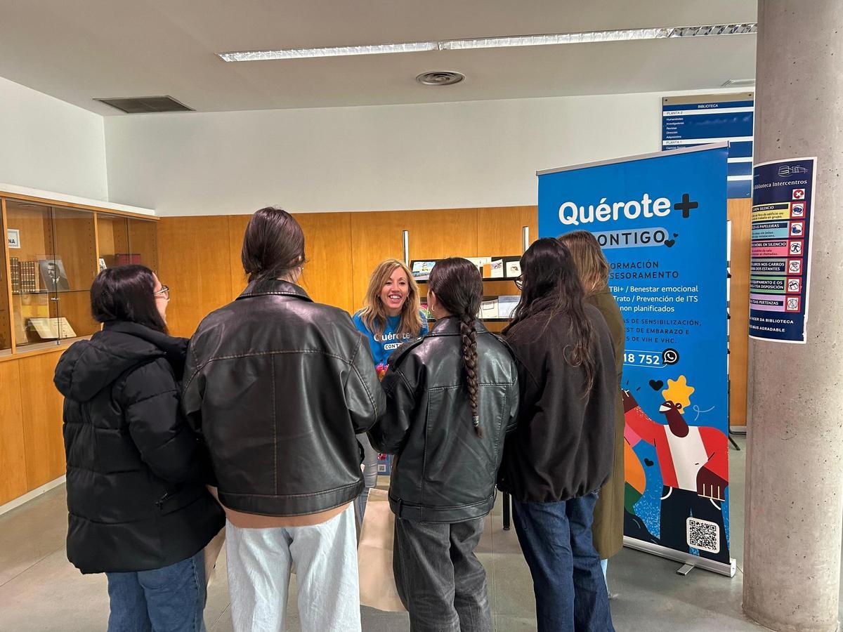 Jóvenes en un puesto informativo de Quérote+.