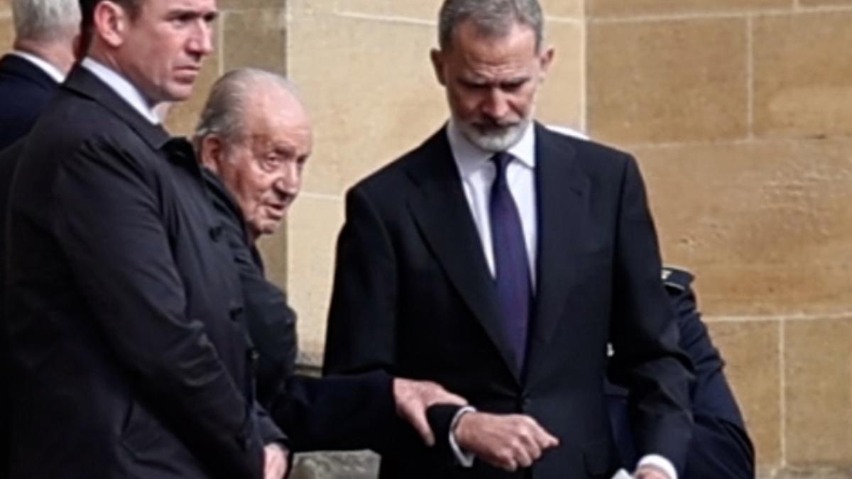 El rey Juan Carlos I saliendo del brazo de su hijo, el rey Felipe VI, del funeral por Constantino de Grecia en el Palacio de Windsor, este martes.