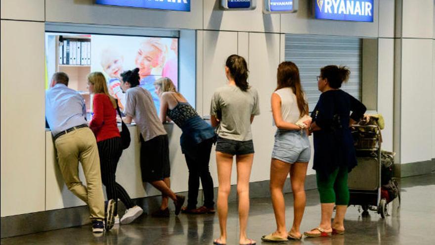 Varios pasajeros hacen cola ante la oficina de Ryanair del aeropuerto de Gran Canaria.